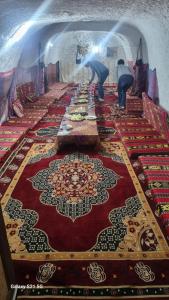 Una larga mesa con alfombras y sombrillas encima. en Dar massouada, en Gabès