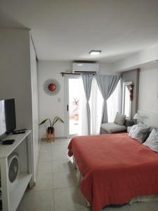 Hermoso departamento céntrico! في سان ميغيل دي توكومان: غرفة نوم بسرير احمر وتلفزيون