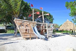 a playground with a slide and flags on a beach at Cozy One-person Studio in Willemstad