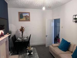 a living room with a couch and a dining room table at Sweet Home NE LTD in Gateshead
