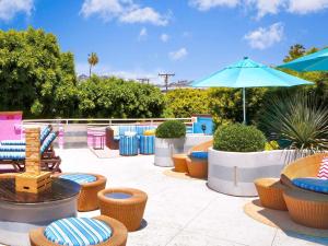 a patio with chairs and tables and an umbrella at Hotel Sofitel Los Angeles at Beverly Hills in Los Angeles