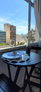 a table with a plate and a wine glass on a window at Studio929GoldStar in Niterói