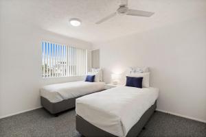 Kymberley - Beachfront Escape at Kingscliff في كينغسكليف: غرفة نوم بها سريرين ونافذة