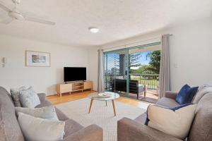 Kymberley - Beachfront Escape at Kingscliff في كينغسكليف: غرفة معيشة مع أريكة وتلفزيون