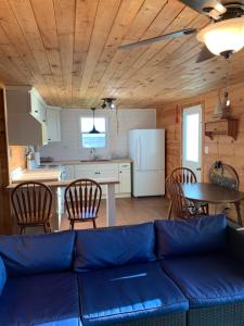 un salon avec un canapé bleu et une cuisine dans l'établissement PEI Ocean Front Beach House, à OʼLeary