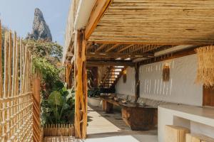un patio in legno con panchine e una montagna sullo sfondo di Villa Milos a Fernando de Noronha