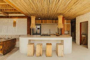 una cucina con bancone bianco e soffitti in legno di Villa Milos a Fernando de Noronha
