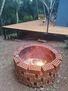 un foyer en briques devant une table de pique-nique dans l'établissement Cabana Pé da Serra, à São Vendelino