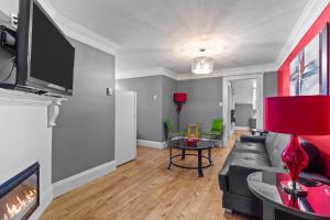 Downtown Gem 2BR Tub Parking في سانت جون: غرفة معيشة مع أريكة وتلفزيون