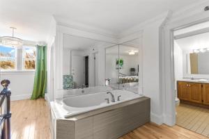 Downtown Gem 2BR Tub Parking في سانت جون: حمام أبيض مع حوض استحمام ومغسلة +11 صورة