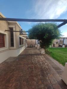 a brick walkway with a tree in a building at El Aura l Complejo de apartamentos amoblados in Villa Krause