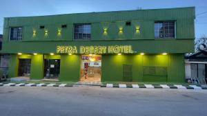 a green building with a sign that readspai desert hotel at Petra Desert Hotel in Wadi Musa