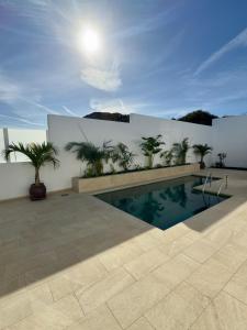 a swimming pool in front of a white wall at CuevaBlanca in Güime