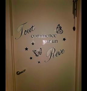 una porta con un cartello con delle farfalle sopra di Le relax & vous a La Louvière