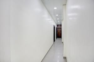 an empty hallway with white walls and white floors at Hotel O Shad Residency in Patna