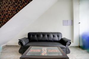 een zwarte leren bank in een woonkamer met een tafel bij Hotel O Shad Residency in Patna +23 foto's