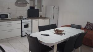 een keuken met een witte tafel en stoelen en een keuken met een bank bij Complejo Picota III in Mar de Ajó