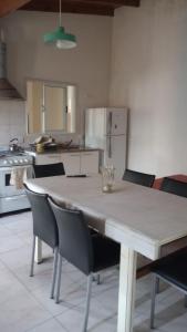 een keuken met een tafel met stoelen en een koelkast bij Complejo Picota III in Mar de Ajó