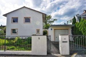 une maison blanche avec un portail et une clôture dans l'établissement Cozy house with courtyard, à Munich