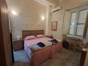 a bedroom with a bed with pink sheets and pink pillows at 63, Casa Falzon in Rabat