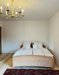 une chambre avec un lit en bois avec un lustre dans l'établissement Cozy house with courtyard, à Munich