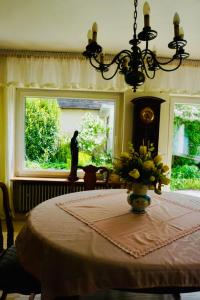 une pièce avec une table et un vase de fleurs sur une fenêtre dans l'établissement Cozy house with courtyard, à Munich
