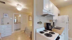 eine Küche mit einem Herd und einem Waschbecken in einem Zimmer in der Unterkunft Driftwood Landing - DWL-1 in Isles of Capri