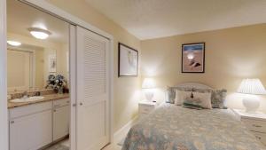 ein Schlafzimmer mit einem Bett, einem Waschbecken und einem Spiegel in der Unterkunft Driftwood Landing - DWL-1 in Isles of Capri