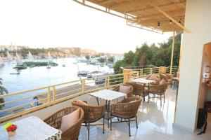 a balcony with tables and chairs and a view of a river at Crystala 2 guest house in Aswan