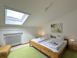 ein Schlafzimmer mit einem großen Bett und einem Fenster in der Unterkunft Gschwendtnerhof App13 Lincke in Aschau im Chiemgau