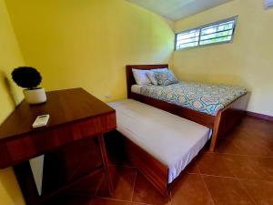 Pura Vida - Villa Lisa في باريتا: غرفة نوم مع مكتب وسرير وطاولة