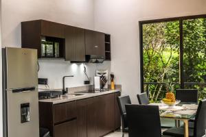 una cocina y comedor con una mesa y un refrigerador en Villa Centinela, en Monteverde