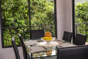 Un comedor con mesa y sillas y una gran ventana. en Villa Centinela, en Monteverde 16 fotos más