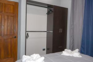 Un dormitorio con espejo y una cama con toallas. en Villa Centinela, en Monteverde