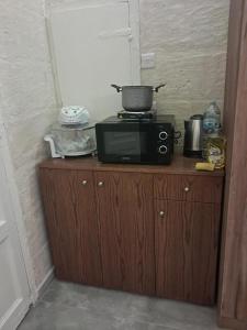 a microwave sitting on top of a wooden cabinet at 63, Casa Falzon in Rabat +6 photos