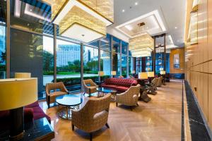 a lobby with chairs and tables and windows at Oakwood Hotel & Residence Suzhou in Suzhou