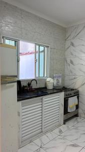 uma cozinha com pia e bancada em SR Casa de férias Astúrias no Guarujá