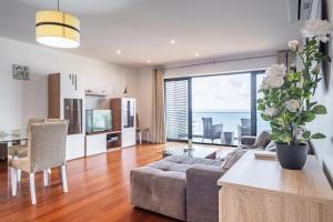 una sala de estar con un sofá y una mesa en Ocean Vista- T2 Funchal, en Bicas