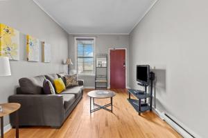 een woonkamer met een bank en een tv bij Cozy 2BR Loft Parking Wi-Fi in St. John's