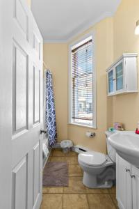 een badkamer met toilet, wastafel en raam bij Cozy 2BR Loft Parking Wi-Fi in St. John's +8 foto's