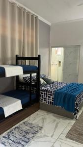 um quarto com dois beliches e um espelho em SR Casa de férias Astúrias no Guarujá