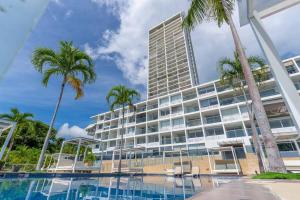 a hotel with palm trees and a swimming pool at 2201 Playa EL Palmar in Las Palmeras