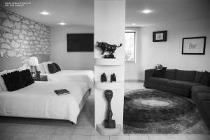 Casa Diamante Hotel Boutique - Mineral de Pozos في Mineral de Pozos: غرفة نوم مع سرير وغرفة معيشة مع أريكة