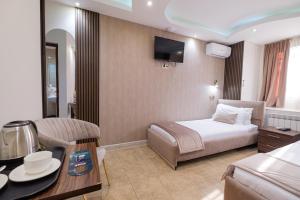 Un pat sau paturi într-o cameră la Grand time hotel +50 fotografii