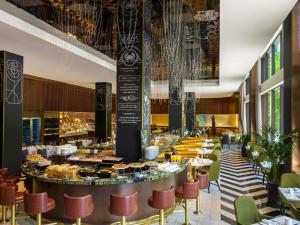 um restaurante com mesas, cadeiras e um bar em Fairmont The Queen Elizabeth em Montréal