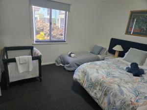 Waterfront Hideaway with Pool, Spa & BBQ Area في ماندورا: غرفة نوم بها سرير وكرسي ونافذة +24 صورة