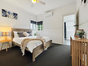 a bedroom with a large bed and a window at Cosy Cottage 4173 in Brisbane