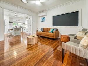 a living room with a couch and a flat screen tv at Cosy Cottage 4173 in Brisbane