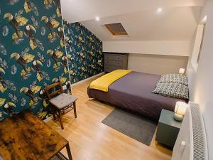a bedroom with a bed and a desk and a tv at T4 en duplex, résidence atypique en pleine forêt in Yzeron