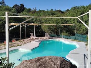 een zwembad in een huis met een rots bij Vado Biguá in Valle Hermoso +56 foto's